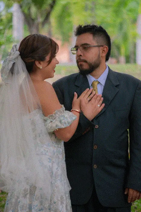 Novios en su boda tomados de la mano en un jardín